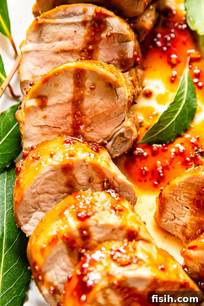 Another perspective on the exquisite slices of mustard and molasses glazed pork tenderloin, highlighting its rich color and inviting texture.