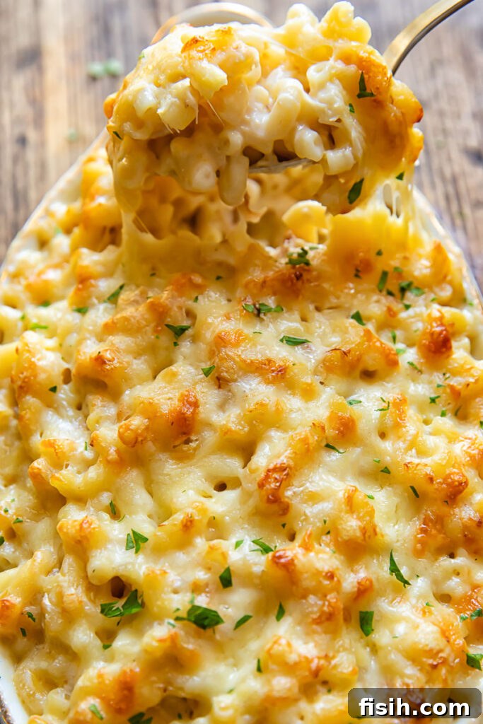 Someone taking a serving of crab mac and cheese from a dish