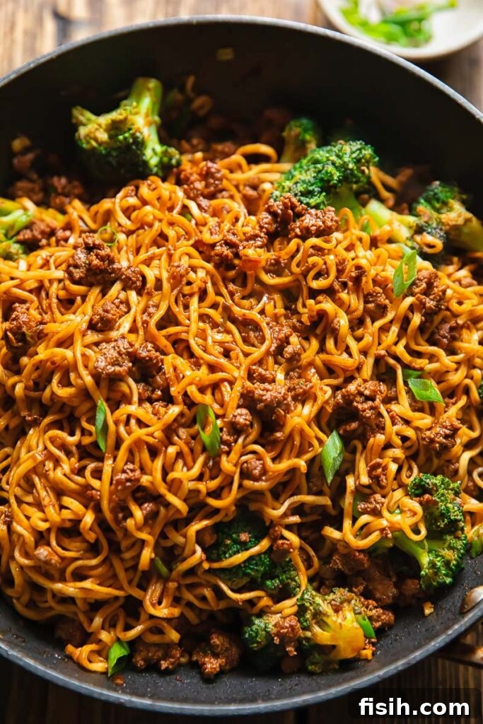Shot of gochujang noodles in a pan with beef and broccoli
