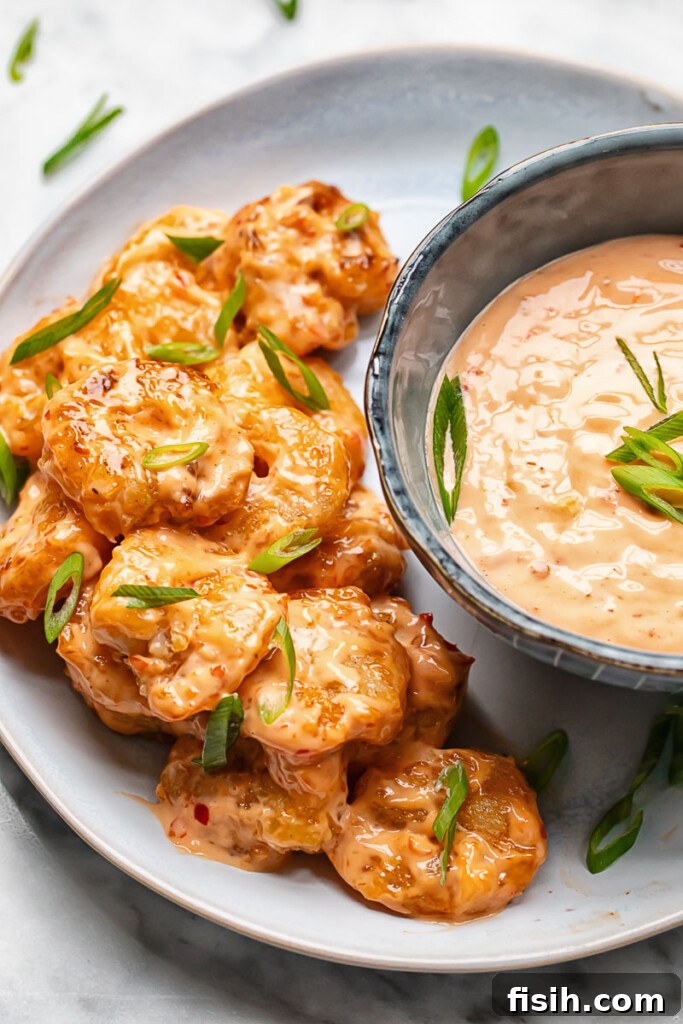Top down shot of bang bang shrimp on a plate with a bowl of spicy mayo
