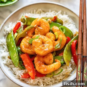 Top down shot of shrimp stir fry in a bowl with chopsticks