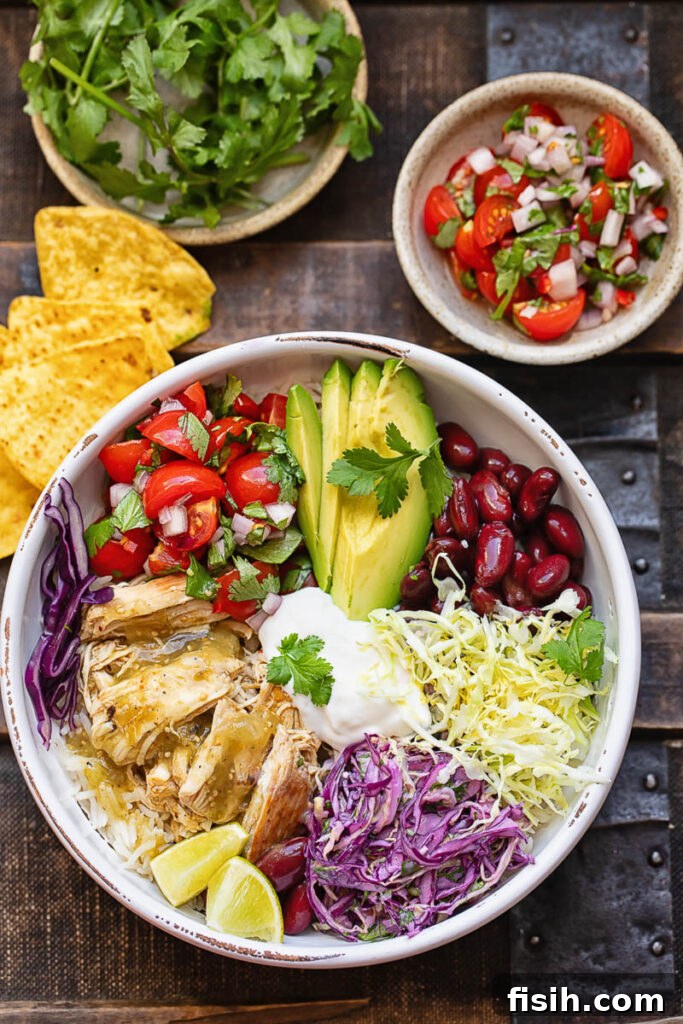Fiesta Chicken Bowl 2 Top down shot of chicken and rice burrito bowls next to fresh veg and salsa toppings