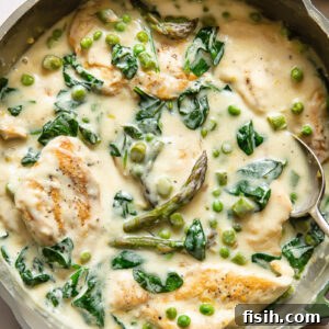 Top down shot of chicken primavera in a pan with creamy sauce