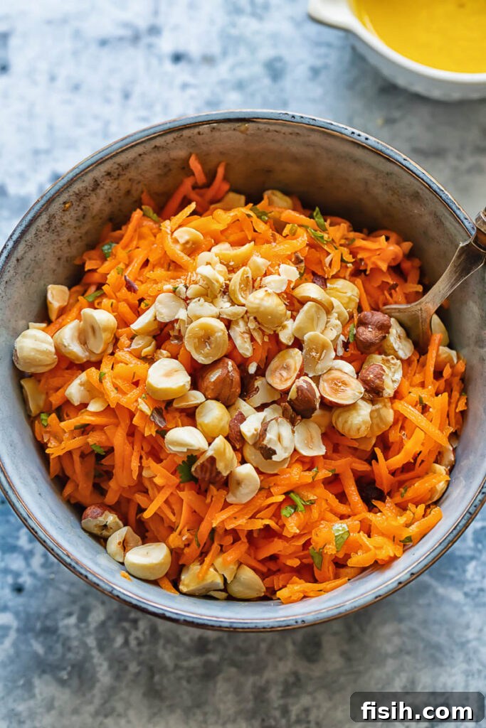 Vibrant French Carrot Salad with Toasted Hazelnut Crumble 4 Top down shot of carrot salad in a bowl topped with hazelnuts