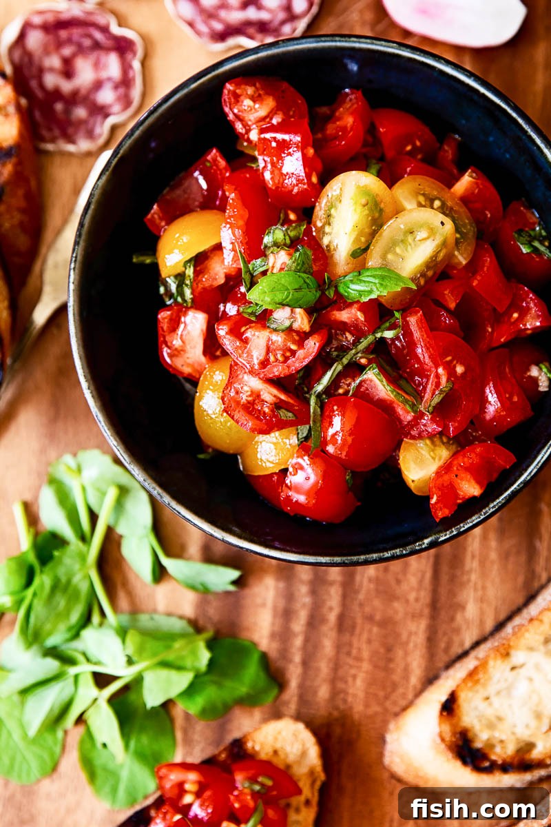 Ultimate Bruschetta Trio 4 Close-up of vibrant Tomato and Basil Bruschetta Topping, ready for a summer party.