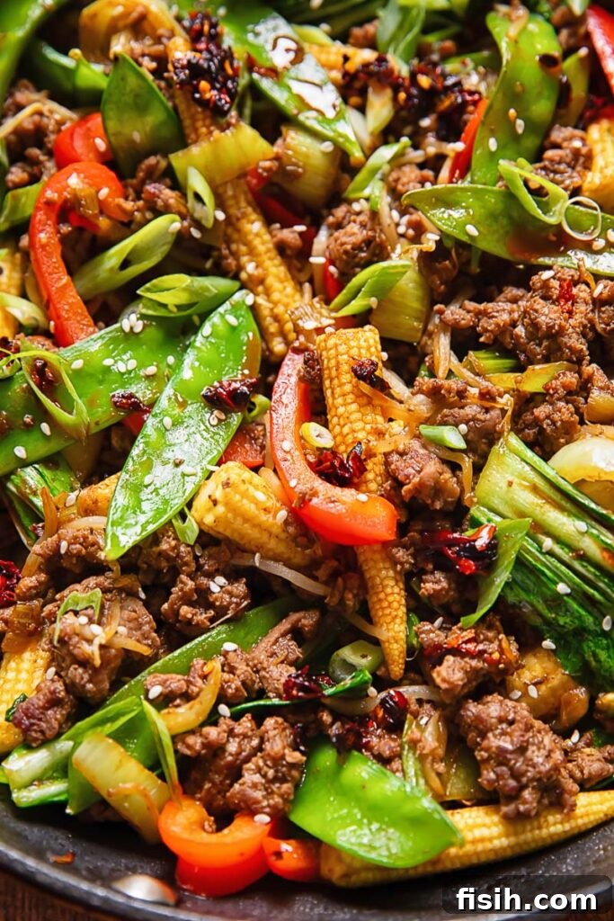 Close up shot of beef stir fry with snow peas, peppers and baby corn