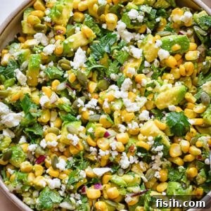Top down shot of avocado and corn salad in a wide bowl, ready to serve.