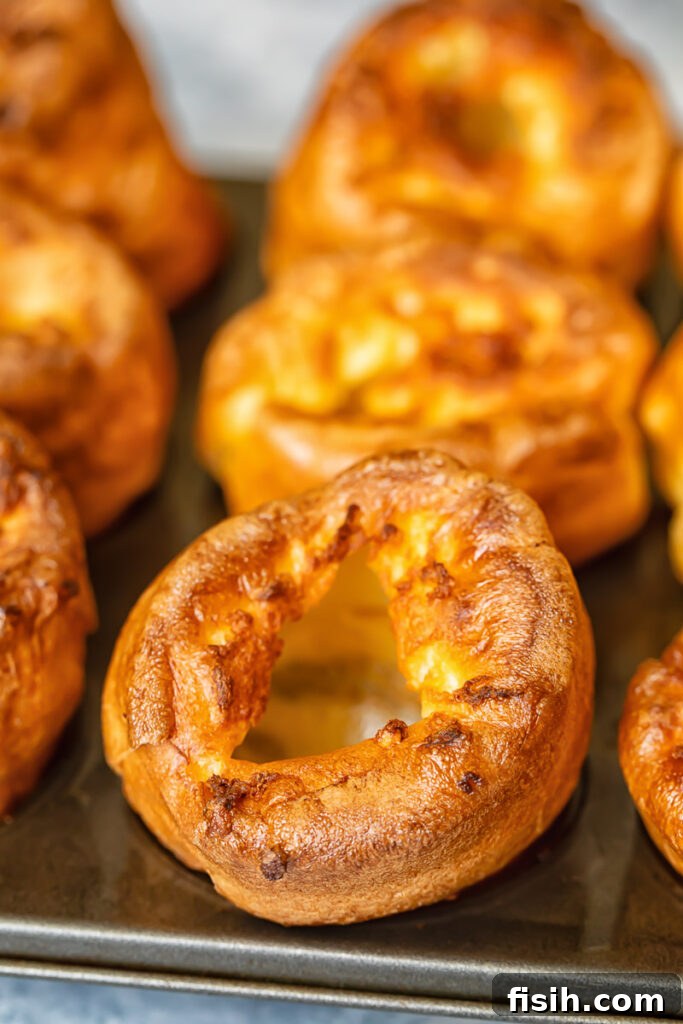 A close-up shot of a single Yorkshire pudding, showing its crispy, golden-brown exterior and airy interior, perfect for holding gravy.