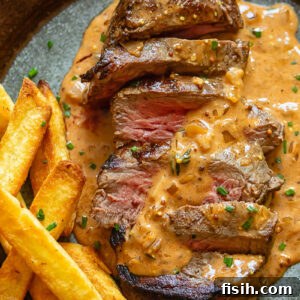 Steak Diane on a plate with fries and creamy sauce
