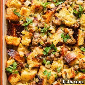 Top-down view of a golden-baked Sausage, Pear and Sage Stuffing in a rustic baking dish, showcasing its rustic, crusty texture and the savory-sweet aroma of its ingredients. Perfect for a holiday feast.