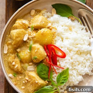 Top down shot of yellow chicken curry with rice on a plate
