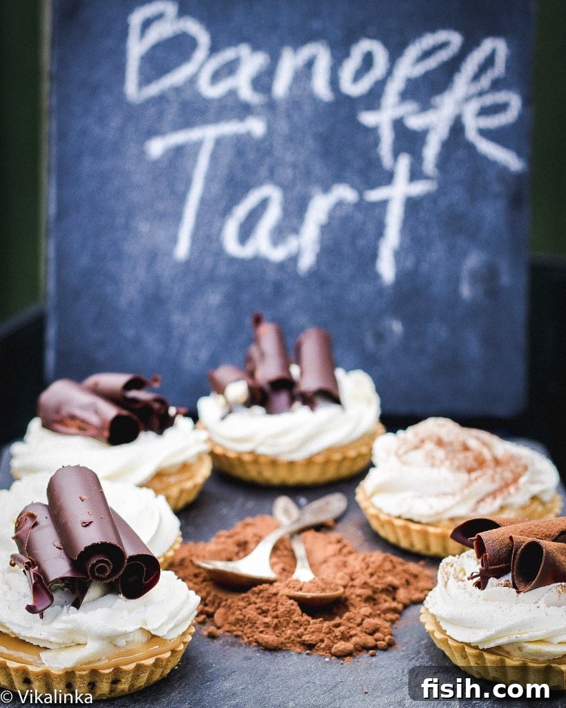 Side shot of banoffee tarts with chocolate powder in the middle on a blue surface