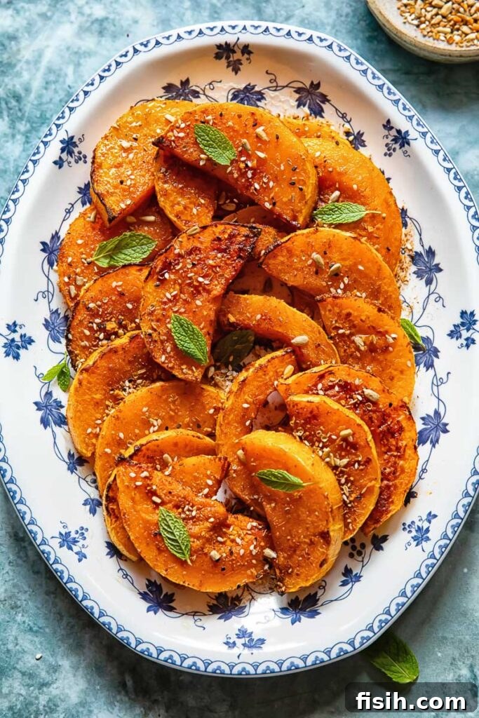 Caramelized Butternut with Fiery Honey 2 Roasted butternut squash slices on a plate with fresh basil garnish