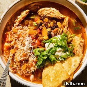 Top-down view of a hearty Instant Pot Chicken Tortilla Soup, vibrant with rice, black beans, corn, and garnished with fresh green onions, ready for toppings.