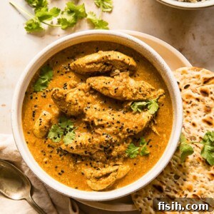 Chicken Korma with a side of warm naan bread and brown basmati rice, ready to be enjoyed.