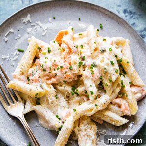 Close-up of creamy pasta with delicate flakes of smoked salmon, garnished with fresh dill.