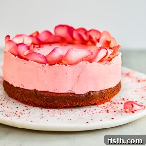 A magnificent red velvet cake, adorned with a blush-pink white chocolate truffle layer and delicate rose petals.