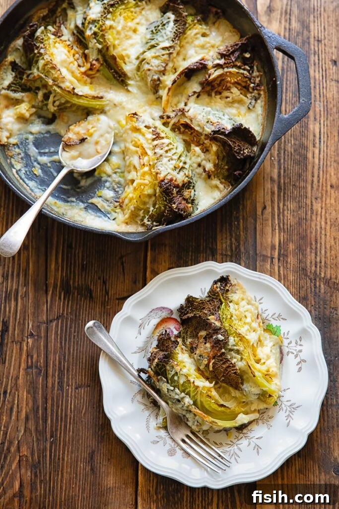 Savoy cabbage gratin in a skillet, with a piece removed to a side plate, on a rustic wooden background.
