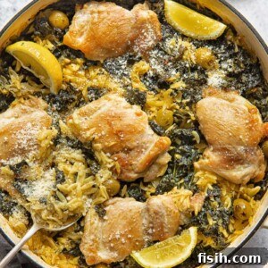 Top-down view of a round pan featuring a vibrant One-Pan Lemon Chicken Orzo Bake, garnished with fresh herbs.