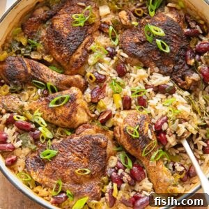 Top-down shot of vibrant Jamaican Jerk Chicken with Rice and Peas, served in a pan with a serving spoon.