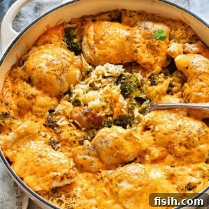 Top-down shot of a cheesy chicken and broccoli rice casserole in a large pan, steaming hot and ready to serve.
