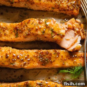 11 Vibrant Salmon Recipes Perfect for Sunny Days 12 Oven-baked salmon fillets on a baking tray, coated in a shiny maple and mustard glaze.