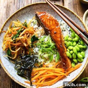 11 Vibrant Salmon Recipes Perfect for Sunny Days 5 A Japanese donburi bowl with teriyaki salmon, edamame beans, and vegetables on a bed of rice.
