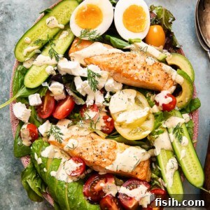 11 Vibrant Salmon Recipes Perfect for Sunny Days 6 A vibrant Salmon Cobb Salad with hard-boiled eggs, avocado, and tomatoes, seen from above.