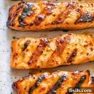 11 Vibrant Salmon Recipes Perfect for Sunny Days 7 Close-up of a grilled salmon fillet with a caramelized maple glaze, showing flaky texture.