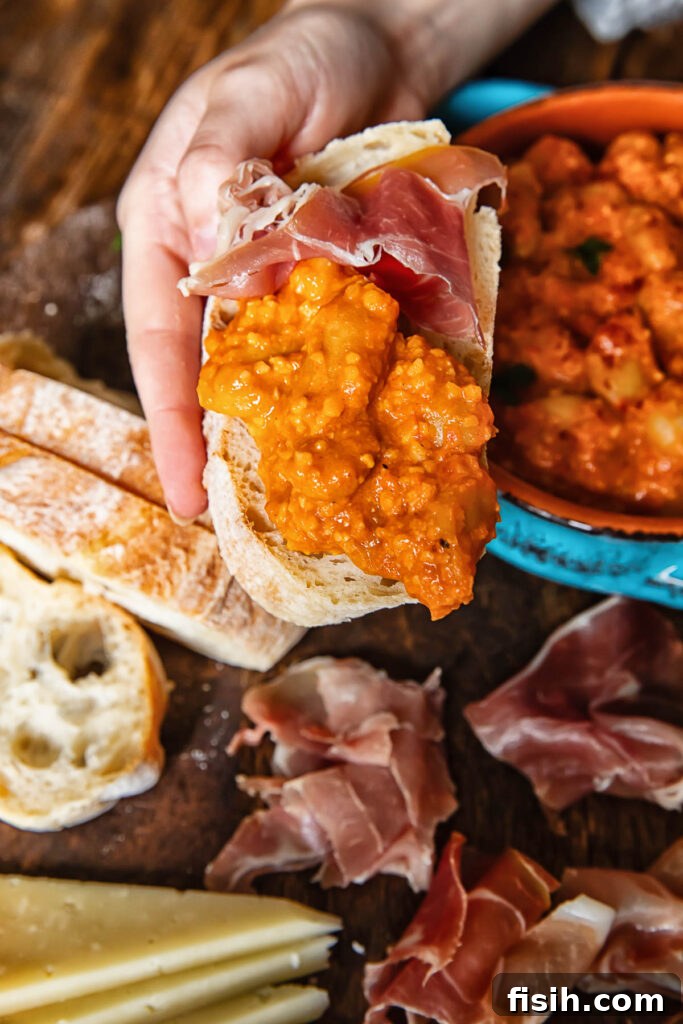 A slice of crusty sourdough bread topped with creamy butter beans in smoky Romesco sauce.