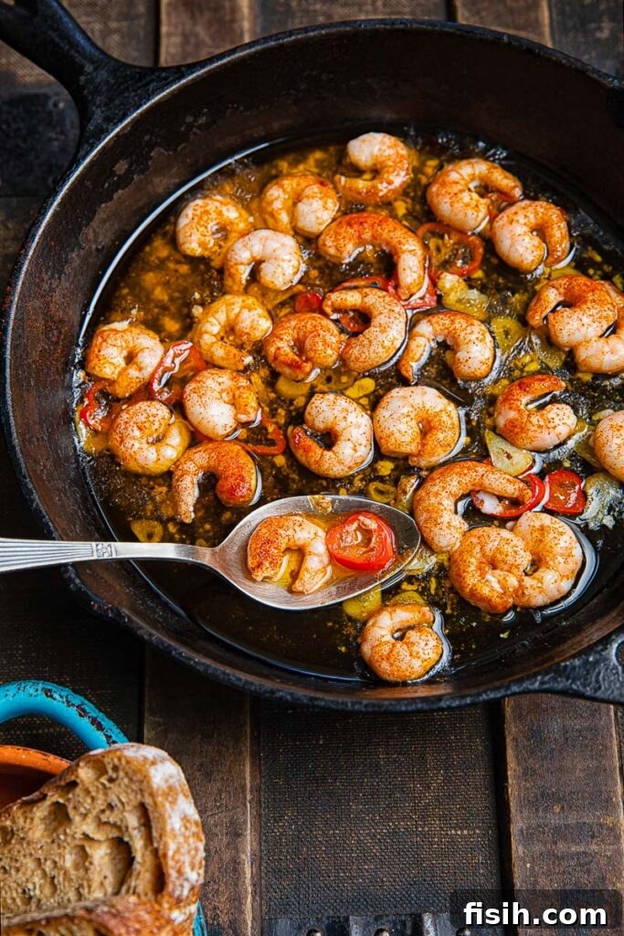 Top down shot of gambas pil pil i a pan with a serving spoon