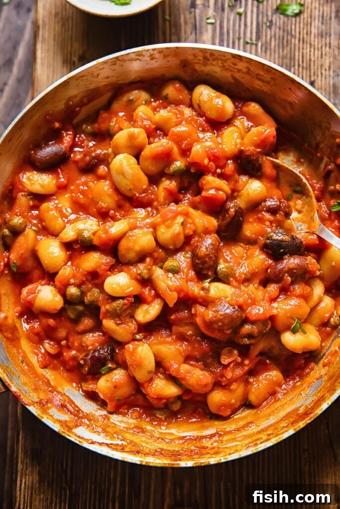 Top down shot of butter beans puttanesca in a pan