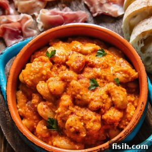 Close up of butter beans in Romesco sauce in a small serving dish