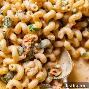 Close up of Mediterranean pasta with zucchini with a serving spoon