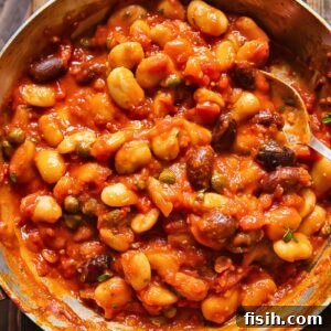 Top down shot of butter beans puttanesca in a pan