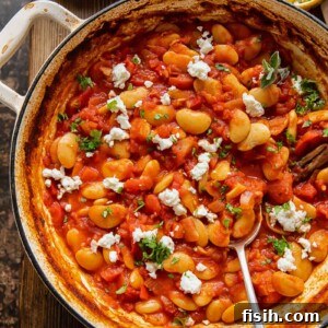 Pan of butter bean stew in a pot with spoon