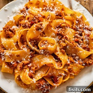 pasta with ragu sauce on a while place and a fork