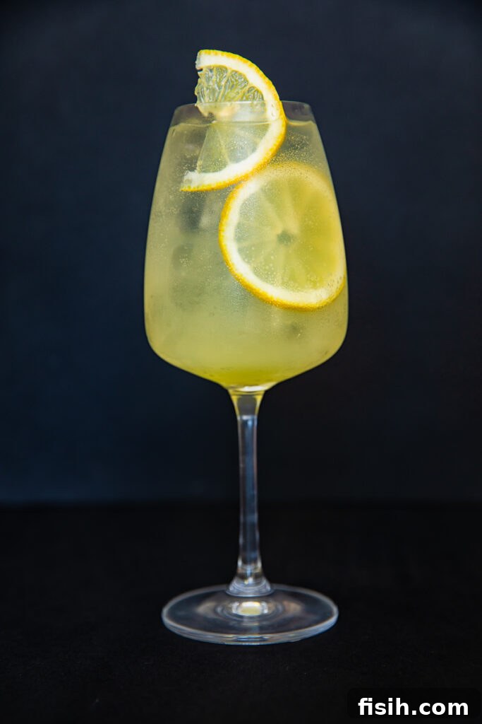 vertical shot of limoncello spritz cocktail against black backdrop