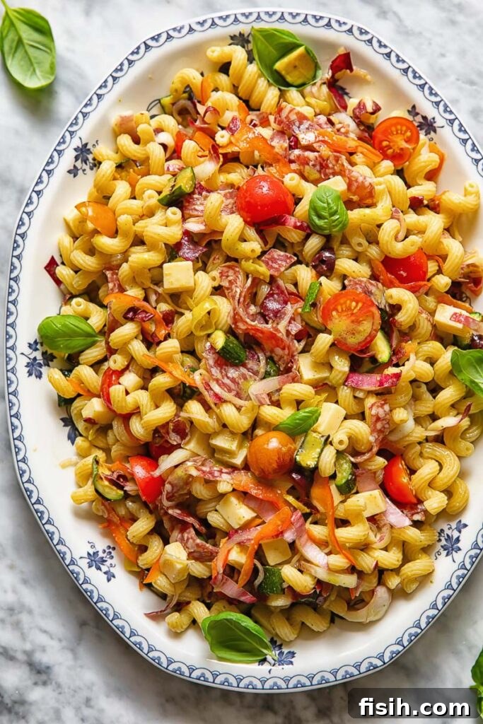 Italian Pasta Salad with Fresh Herbs and Cherry Tomatoes 2 vertical shot of Italian pasta salad on a white platter