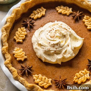 top down view of pumpkin pie topped with whipped cream in the middle