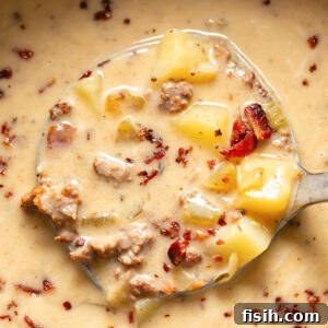 Close up shot of bacon cheeseburger soup being ladled out of a pot