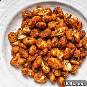 A pile of spiced butter beans on a white plate against a wood background.
